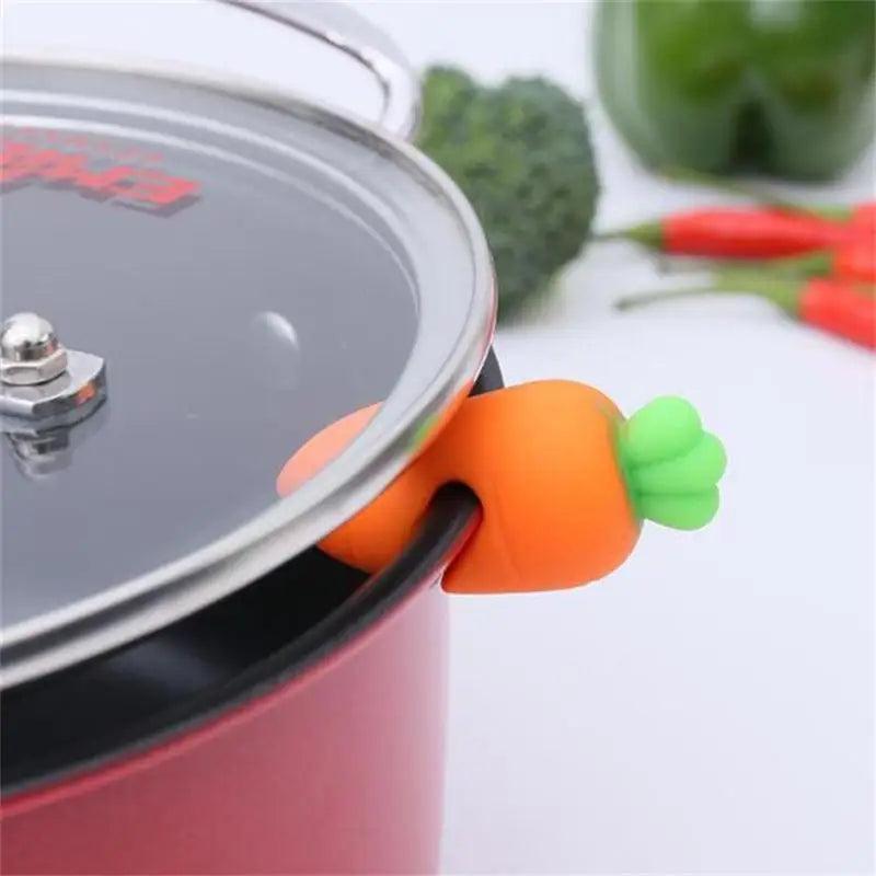 Cute Silicone Pot Lid Lifter - Carrot-shaped lid lifter in use, lifting a pot lid safely.