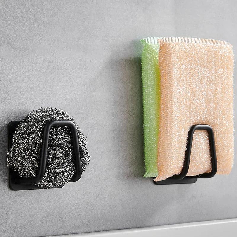 Kitchen Organizer: Black organizers holding sponges on wall.