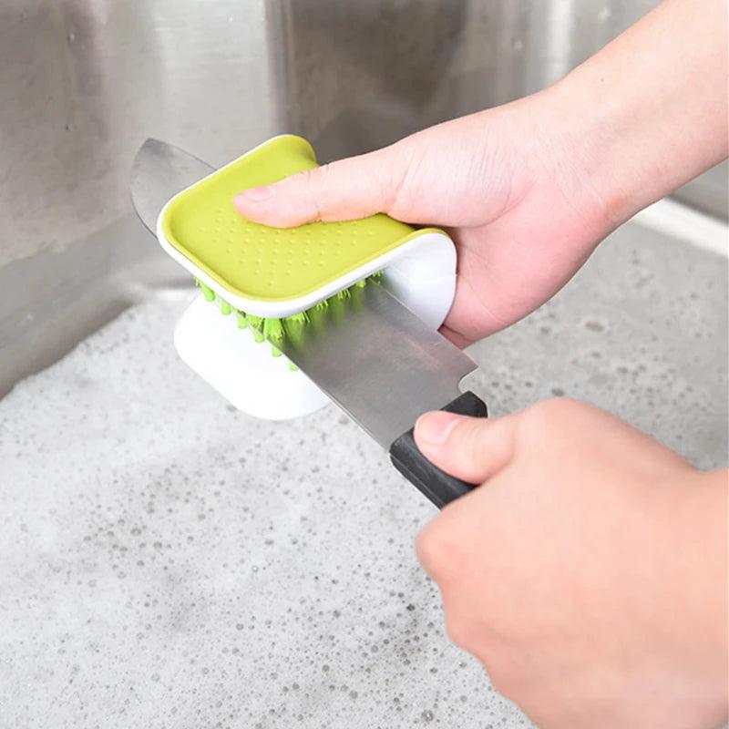 Sink Hero Utensil Scrubber - In use scrubbing a utensil under running water.